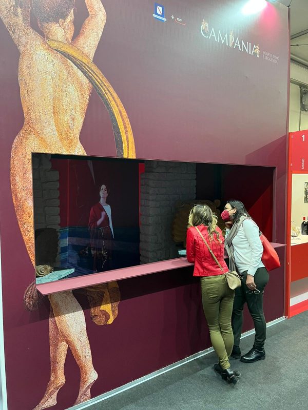ragazze che osservano l'ologramma dall'esterno dle box in vinitaly